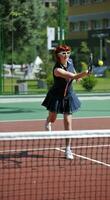 mujer joven jugar juego de tenis al aire libre foto