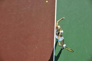 mujer joven jugar al tenis al aire libre foto