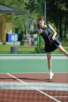 mujer joven jugar juego de tenis al aire libre foto