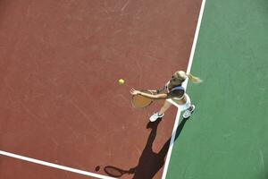 mujer joven jugar al tenis al aire libre foto