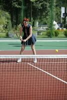 mujer joven jugar juego de tenis al aire libre foto