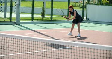 mujer joven jugar juego de tenis al aire libre foto