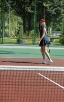 mujer joven jugar juego de tenis al aire libre foto