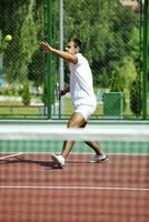 joven jugar al tenis al aire libre foto