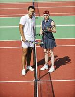 happy young couple play tennis game outdoor photo