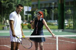 happy young couple play tennis game outdoor photo