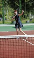 mujer joven jugar juego de tenis al aire libre foto