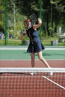 mujer joven jugar juego de tenis al aire libre foto