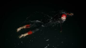 triathlon athlete swimming in dark night  wearing wetsuit photo