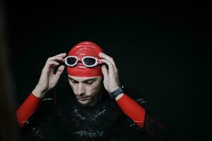 authentic triathlete swimmer having a break during hard training on night photo