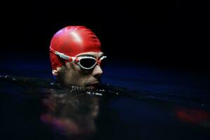 authentic triathlete swimmer having a break during hard training on night photo