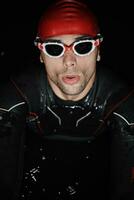 authentic triathlete swimmer having a break during hard training on night photo