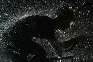 triathlon athlete riding bike  fast on rainy night photo