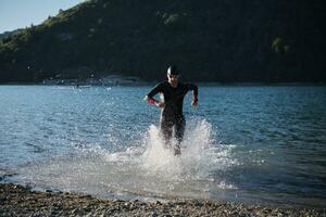 triathlon athlete starting swimming training on lake photo