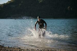 triathlon athlete starting swimming training on lake photo