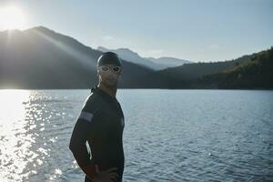 triathlon athlete starting swimming training on lake photo