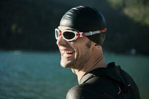 triathlon athlete starting swimming training on lake photo