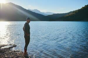 triathlon athlete starting swimming training on lake photo