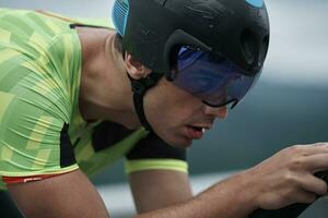 atleta de triatlón montando en bicicleta en el entrenamiento matutino foto