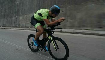 atleta de triatlón montando en bicicleta en el entrenamiento matutino foto