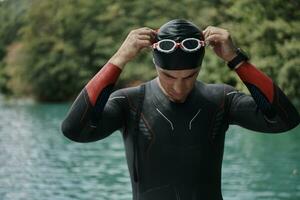 atleta de triatlón preparándose para el entrenamiento de natación en el lago foto