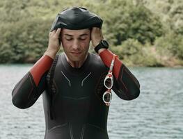 triathlon athlete getting ready for swimming training on lake photo