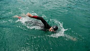 atleta de triatlón nadando en el lago con traje de neopreno foto