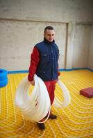 workers installing underfloor heating system photo