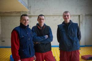 workers installing underfloor heating system photo