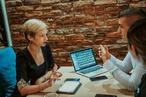 Happy businesspeople smiling cheerfully during a meeting in a coffee shop. Group of successful business professionals working as a team in a multicultural workplace. photo