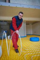 workers installing underfloor heating system photo