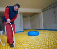 workers installing underfloor heating system photo