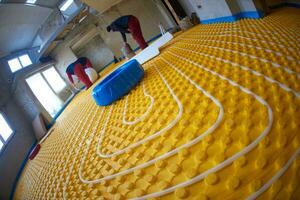 workers installing underfloor heating system photo