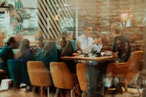 contento gente de negocios sonriente alegremente durante un reunión en un café tienda. grupo de exitoso negocio profesionales trabajando como un equipo en un multicultural lugar de trabajo. foto