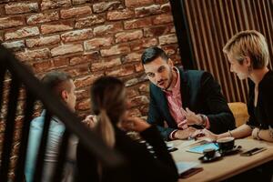 contento gente de negocios sonriente alegremente durante un reunión en un café tienda. grupo de exitoso negocio profesionales trabajando como un equipo en un multicultural lugar de trabajo. foto