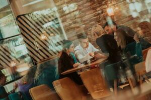 contento gente de negocios sonriente alegremente durante un reunión en un café tienda. grupo de exitoso negocio profesionales trabajando como un equipo en un multicultural lugar de trabajo. foto