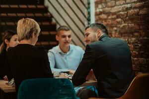 contento gente de negocios sonriente alegremente durante un reunión en un café tienda. grupo de exitoso negocio profesionales trabajando como un equipo en un multicultural lugar de trabajo. foto