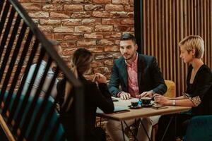 contento gente de negocios sonriente alegremente durante un reunión en un café tienda. grupo de exitoso negocio profesionales trabajando como un equipo en un multicultural lugar de trabajo. foto