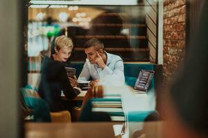 Happy businesspeople smiling cheerfully during a meeting in a coffee shop. Group of successful business professionals working as a team in a multicultural workplace. photo