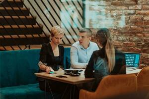 contento gente de negocios sonriente alegremente durante un reunión en un café tienda. grupo de exitoso negocio profesionales trabajando como un equipo en un multicultural lugar de trabajo. foto