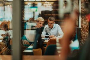 contento gente de negocios sonriente alegremente durante un reunión en un café tienda. grupo de exitoso negocio profesionales trabajando como un equipo en un multicultural lugar de trabajo. foto