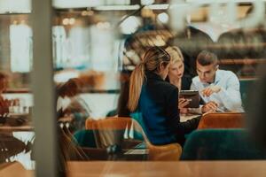 Happy businesspeople smiling cheerfully during a meeting in a coffee shop. Group of successful business professionals working as a team in a multicultural workplace. photo