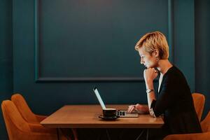 Businesswoman sitting in a cafe while focused on working on a laptop and participating in an online meetings. Selective focus. High quality photo