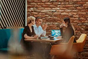 Happy businesspeople smiling cheerfully during a meeting in a coffee shop. Group of successful business professionals working as a team in a multicultural workplace. photo