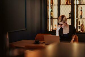 Businesswomen are stressed while working on laptop, Tired businesswoman with headache in coffee shop , feeling sick at work. Selective focus photo