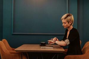 Businesswoman sitting in a cafe while focused on working on a laptop and participating in an online meetings. Selective focus. High quality photo