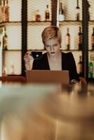 Businesswoman sitting in a cafe while focused on working on a laptop and participating in an online meetings. Selective focus. High quality photo