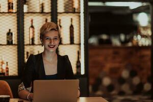 Businesswoman sitting in a cafe while focused on working on a laptop and participating in an online meetings. Selective focus. High quality photo