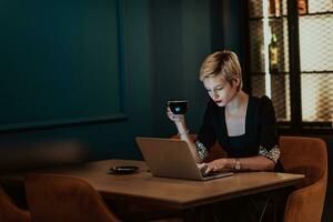 Businesswoman sitting in a cafe while focused on working on a laptop and participating in an online meetings. Selective focus. High quality photo