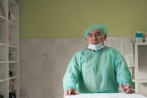 Mature confident doctor standing in front of surgery room - focus on the face photo